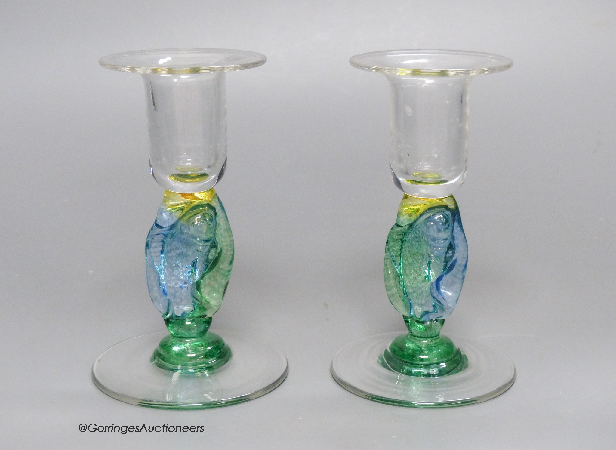 A pair of clear and coloured glass candlesticks by Helen Millard